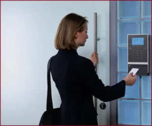 Frau öffnet Haustür mit Karte an Zugriffskontrollsystem