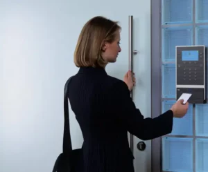 Frau öffnet Haustür mit Karte an Zugriffskontrollsystem